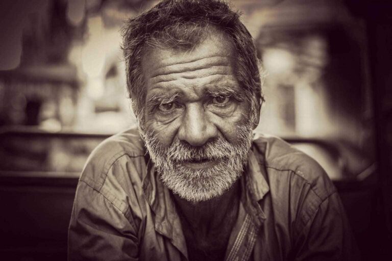Old man with a beard looking into camera