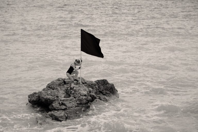 Woman putting a black flag on an island