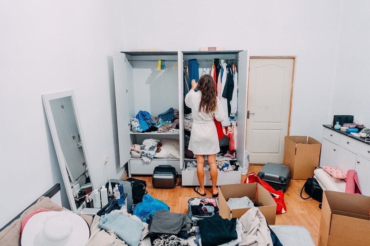 Young woman in cluttered apartment