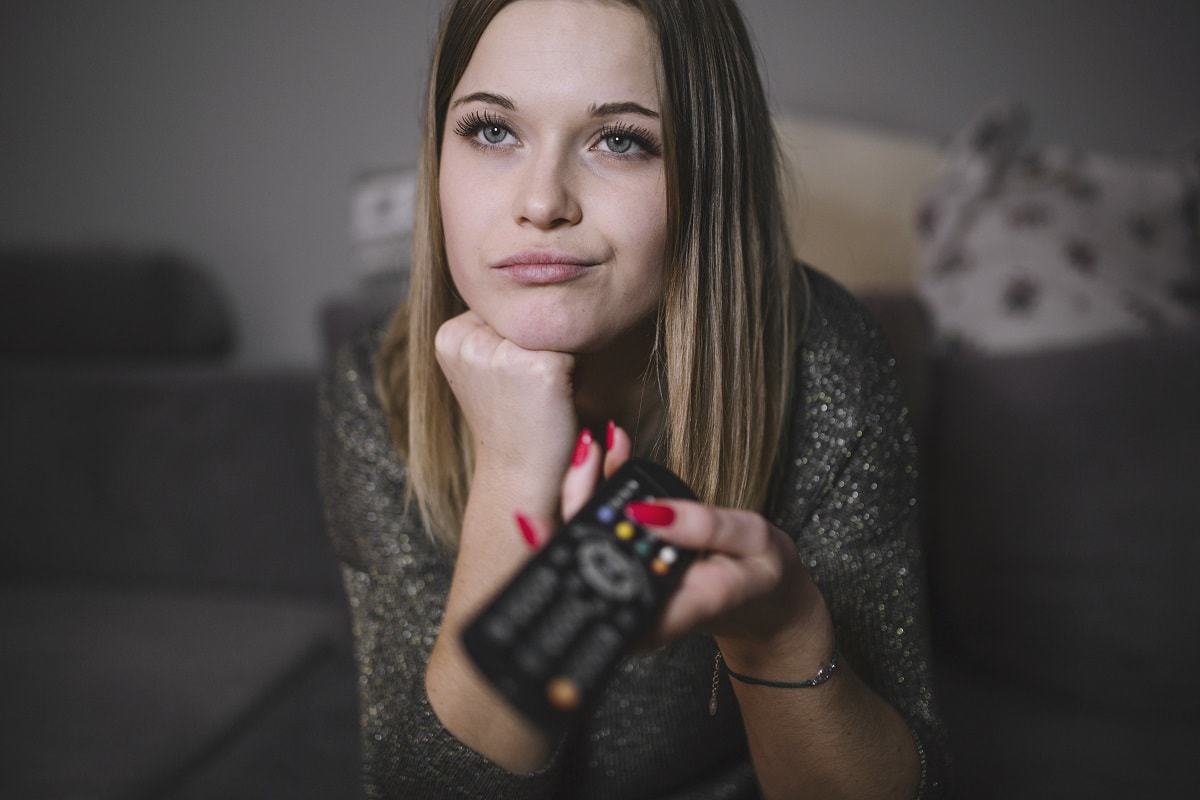 Woman with unhealthy boredom switching tv channels